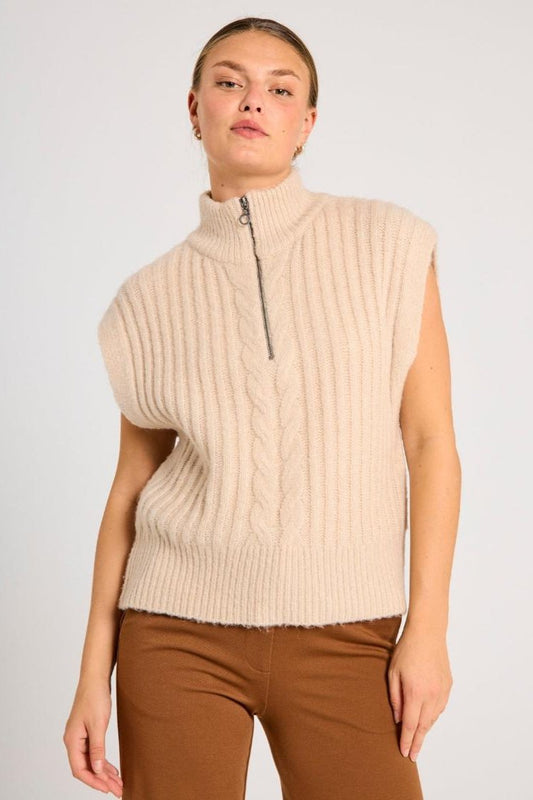 En beige vest med kabelstrikk